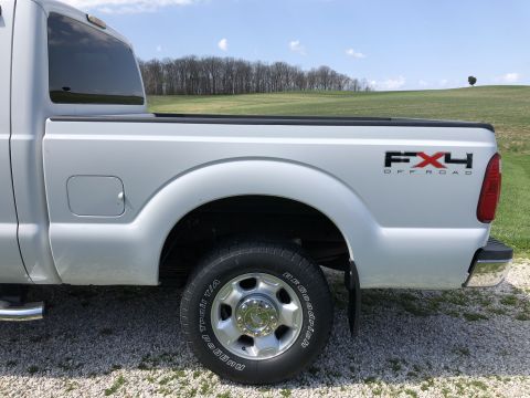 2011 Ford F-250 - The rear quarter panel and wheel of a white Ford F-250 pickup truck is shown in this side view. The truck has an FX4 Off-Road decal on the…