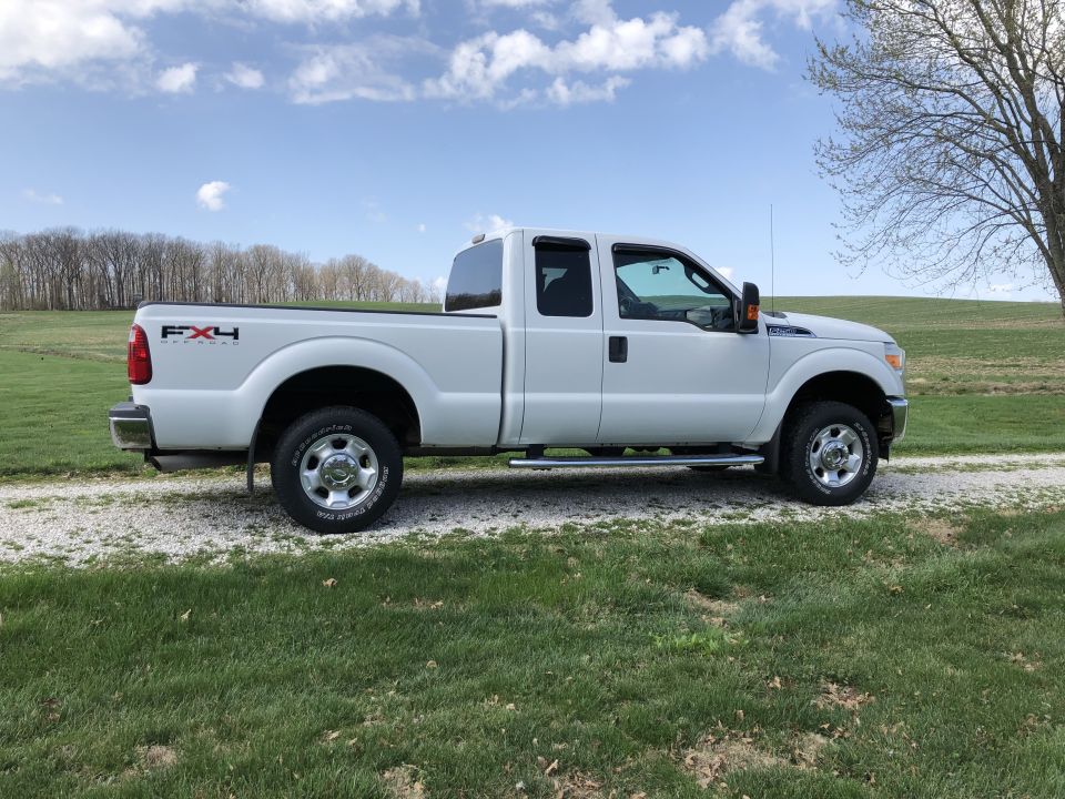 White Ford F-250 Super Duty pickup truck parked on a gravel driveway.