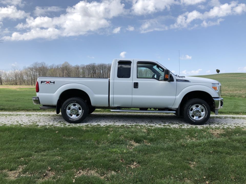 White Ford F-250 pickup truck parked on a gravel road.