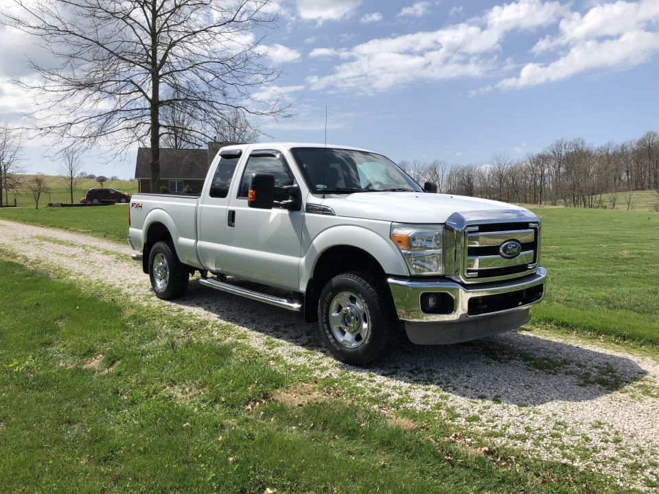 White Ford F-250 Super Duty pickup truck parked on a gravel driveway.