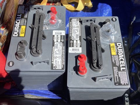 2015 Ford F-550 - Two Duracell Group 31 batteries are shown in a close-up overhead view. The batteries have red terminal covers and black carrying handles.