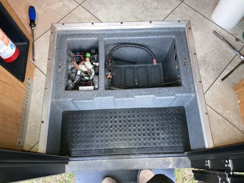 2015 Ford F-550 - A close-up view shows an open compartment containing electrical components, wiring, and a battery cable. A screwdriver and a socket wrench…