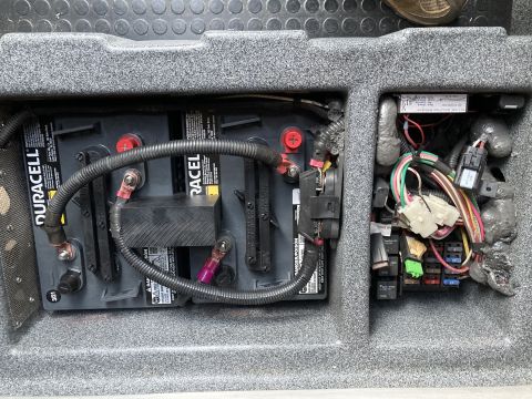 2015 Ford F-550 - Close-up view of house batteries and the vehicle's fuse box and wiring.