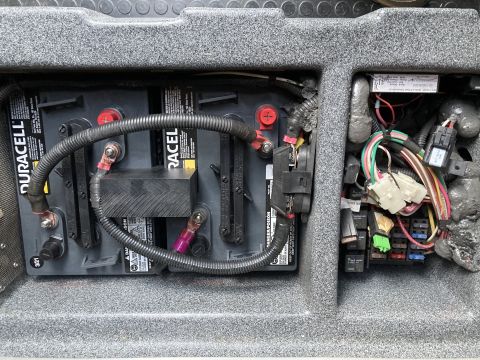 2015 Ford F-550 - Vehicle battery compartment showing two batteries, wiring, and a fuse box.