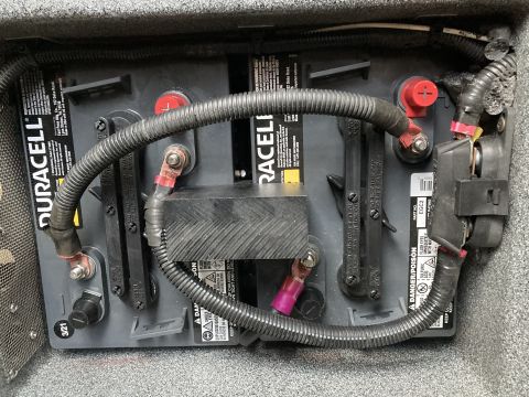 2015 Ford F-550 - Close-up view of a vehicle's battery setup, showing two batteries connected by wiring and protective conduits.