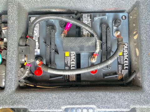 2015 Ford F-550 - House batteries are visible with Duracell branding and corrugated wire loom connecting terminals.