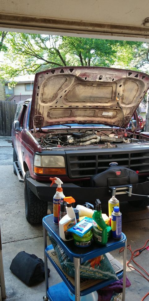 1996 Ford Bronco - Front view of a 1996 Ford Bronco with its hood open, parked in a garage with cleaning supplies nearby.