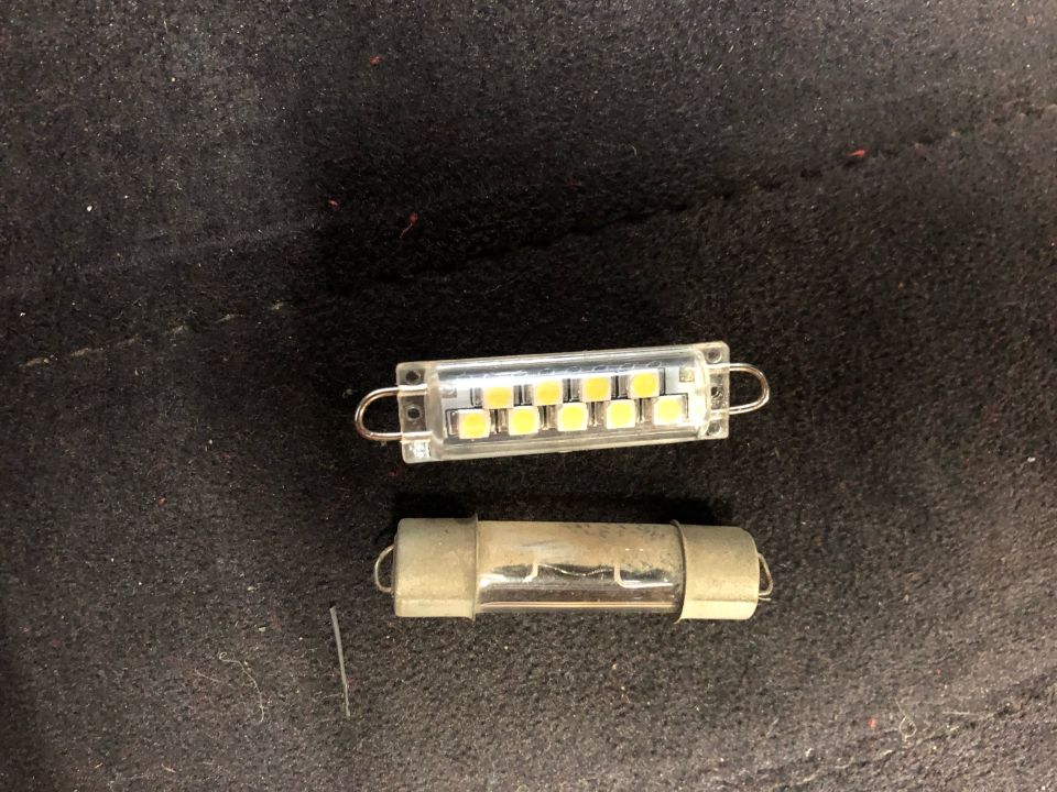 LED and incandescent automotive bulbs side-by-side on dark fabric