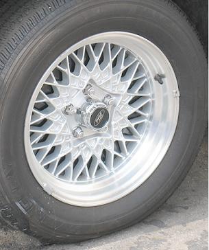 1997 Ford Crown Victoria - A close-up view of a silver alloy wheel a Ford logo on the center cap and a tire.