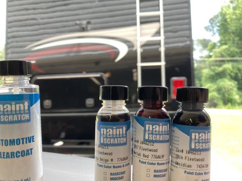 2015 Ford F-550 - Three small bottles of touch-up paint are lined up in front of a large RV or motorhome. The bottles are labeled "Paint Scratch" and contain…