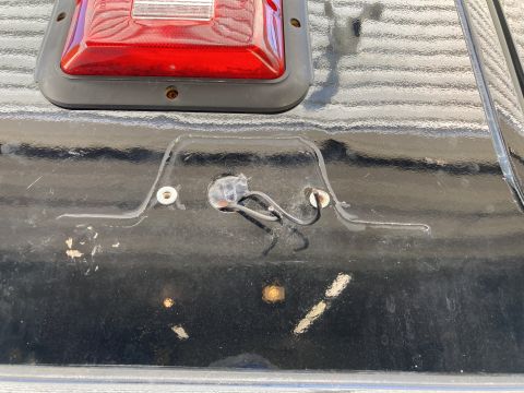 2015 Ford F-550 - A close-up view shows the wiring harness for a taillight assembly on the black tailgate of a truck. The taillight assembly is partially vis…