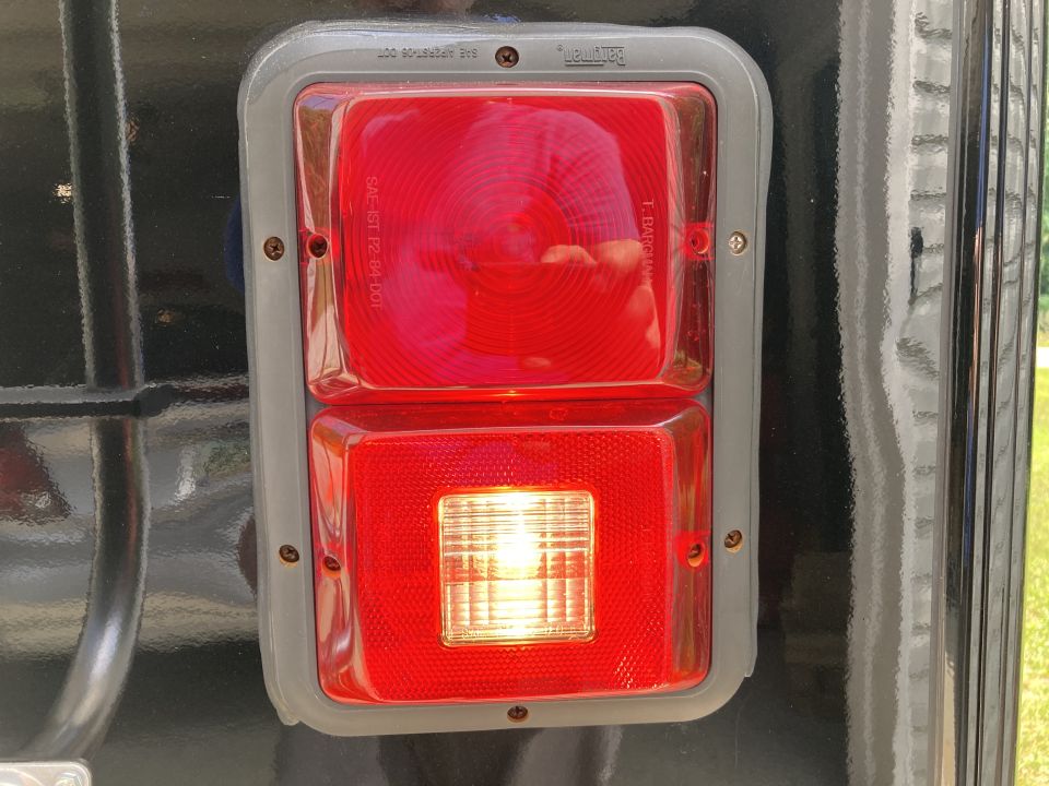 Close-up of a red and clear rectangular taillight assembly on a black vehicle.
