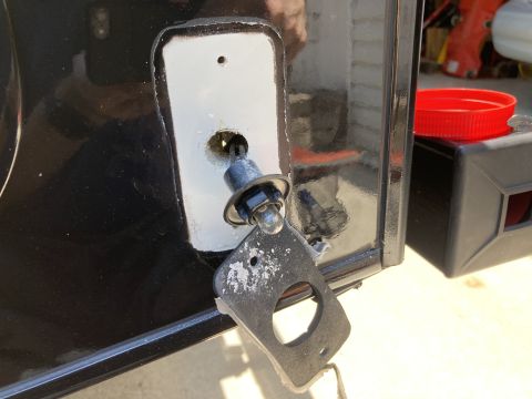 2015 Ford F-550 - A close-up view shows a black vehicle's exterior with a partially removed light fixture and mounting plate. A red plastic cap rests on a bl…
