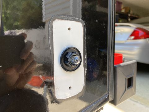 2015 Ford F-550 - A close-up view of a black vehicle's exterior shows a white rectangular gasket with a single bulb light fixture mounted in the center. The…