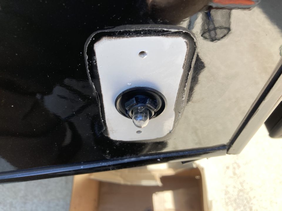 Close-up of a vehicle's exterior light bulb with black housing on a white gasket.