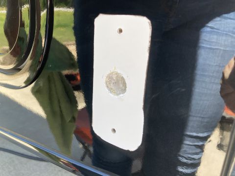 2015 Ford F-550 - A close-up view shows a white rectangular plate with two screw holes and a central circular opening on a glossy black surface. The opening…