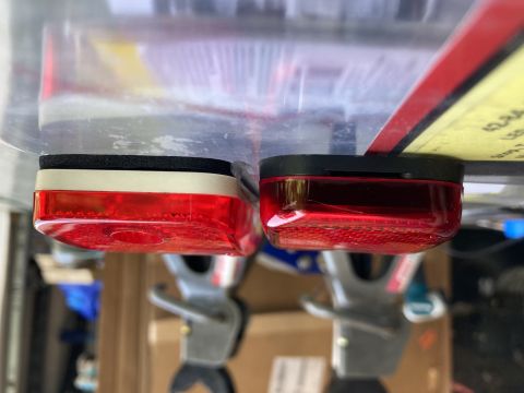 2015 Ford F-550 - Two red rectangular trailer lights are shown mounted underneath a clear plastic container. The light on the left has a white mounting gaske…