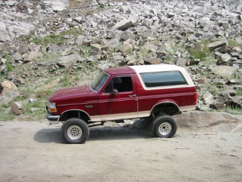 1985 Ford Bronco - This lifted Ford Bronco navigates a rocky, off-road terrain.