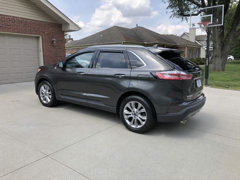 2019 Ford Everest - A dark gray Ford Edge is parked in a suburban driveway, showing its rear 3/4 profile.