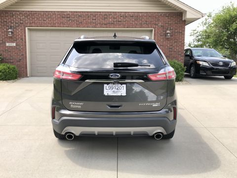 2019 Ford Everest - 2019 Ford Edge Titanium SUV seen from the rear, parked in front of a brick house and garage.