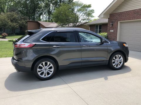 2019 Ford Everest - This gray Ford Edge SUV is parked on a concrete driveway in front of a brick house.