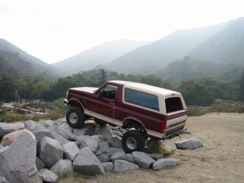 1985 Ford Bronco - This lifted Ford Bronco navigates a rocky terrain, its off-road capabilities.