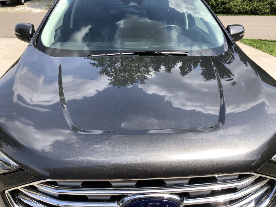 Front view of a dark gray Ford Everest SUV with reflections on the hood.
