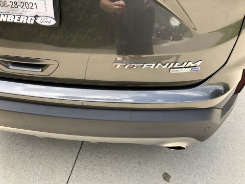 2019 Ford Everest - The rear bumper and tailgate of a dark gray SUV are shown. Visible badging includes "TITANIUM" and "ECOBOOST AWD".