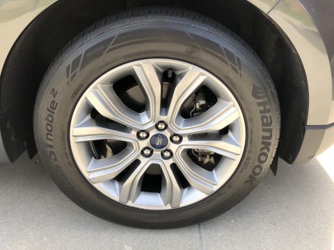 2019 Ford Everest - A close-up, straight-on shot of the front passenger-side wheel and tire of a dark gray SUV. The tire is a Hankook Ventus S1 Noble 2, and th…