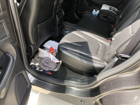 2019 Ford Everest - The interior of a dark-colored SUV shows the rear seats and floor with various items scattered on the floor mats. Visible items include cha…