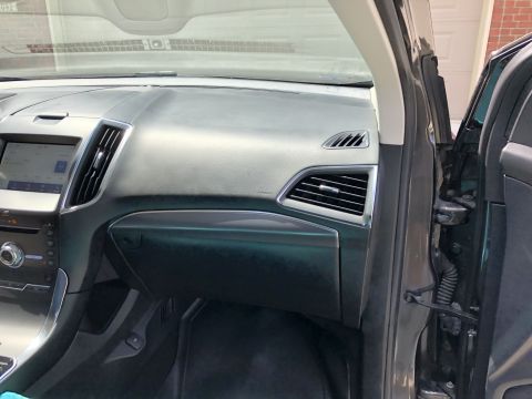 2019 Ford Everest - The interior of a modern SUV's dashboard is shown, focusing on the center console and air vents. The driver's side door is open, revealing…