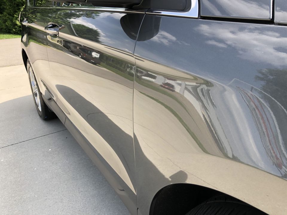 Dark gray SUV side view, showing reflections on the glossy paint.