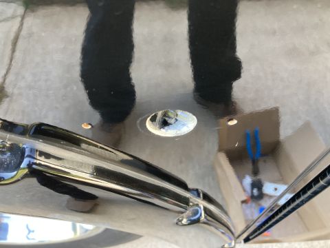 2015 Ford F-550 - A close-up shot shows a shiny black surface with reflections of legs and a hole drilled into it. A chrome trim piece is visible in the fore…
