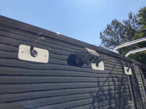 2015 Ford F-550 - A black RV roof is shown with three white mounting plates. One plate has a visible camera attached, and two others have exposed wires protr…