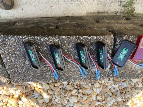 2015 Ford F-550 - Five black rectangular LED trailer lights with visible circuit boards and wiring are laid out on a concrete ledge next to a pile of gravel.…
