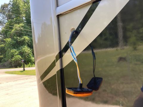 2015 Ford F-550 - A close-up view of an orange marker light with exposed wiring connected to a RV body, featuring a diagonal stripe design.