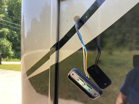 2015 Ford F-550 - A close-up view shows wiring and a disassembled LED light fixture attached to the side of a motorhome with a black and tan stripe graphic.…
