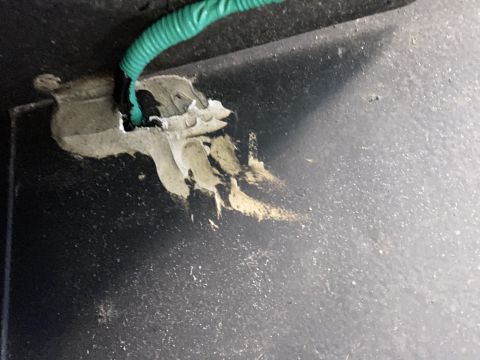 2015 Ford F-550 - A close-up view shows a green wire connected to a black component, secured with a grey sealant on a black surface. The sealant appears to b…