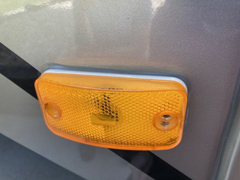 2015 Ford F-550 - A close-up view of an amber clearance light with a textured lens mounted on the side of a vehicle. The light housing is orange and appears…