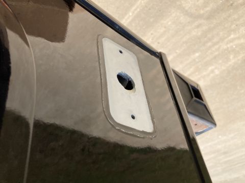 2015 Ford F-550 - A close-up view shows a rectangular mounting plate with a central hole and two screw holes on a glossy black surface, likely part of a vehi…