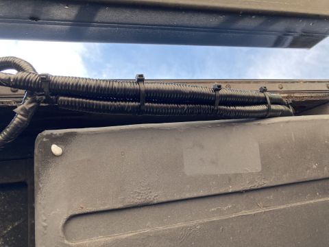 2015 Ford F-550 - A close-up view of a bundle of wires protected by corrugated conduit and secured with zip ties.