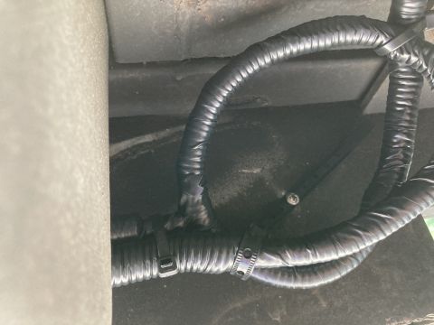 2015 Ford F-550 - Close-up view of a black wiring harness running along the underbody of a vehicle, held in place by black zip ties.