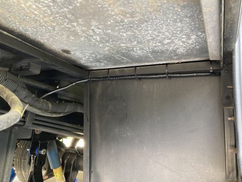 2015 Ford F-550 - Close-up view of the undercarriage, showing organized wiring and a large component box.