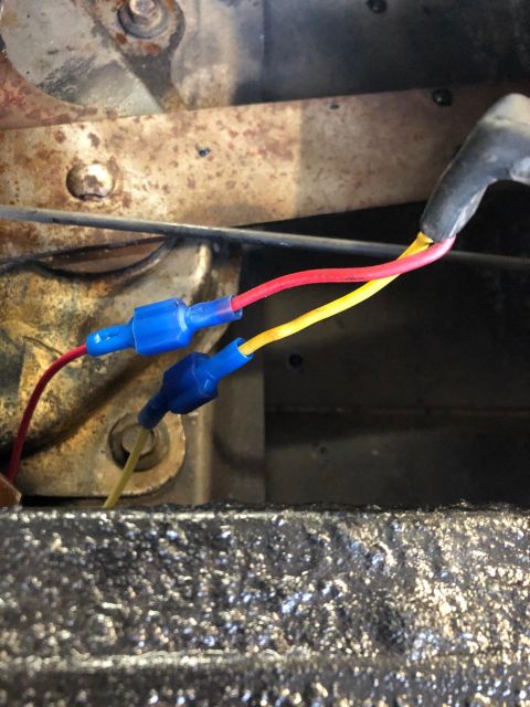1978 Ford Bronco - Two wires, one red and one yellow, are connected with blue crimp connectors to other wires. The wires appear to be part of a vehicle's elec…