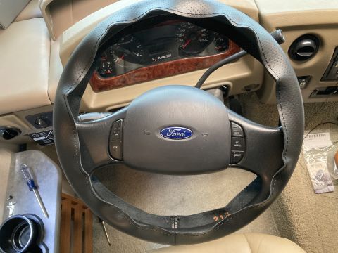 2015 Ford F-550 - Close-up of a Ford steering wheel and dashboard, with a steering wheel cover installed.