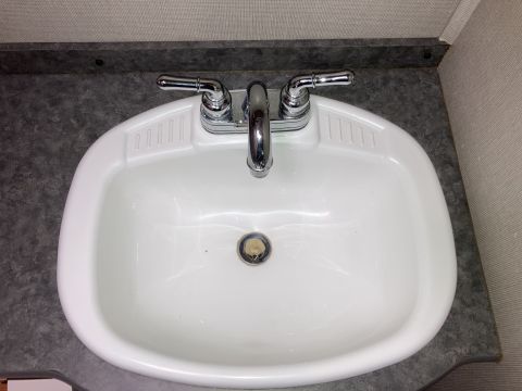 2015 Ford F-550 - Close-up of a bathroom sink with a chrome faucet and drain assembly.