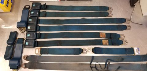 1973 Chevrolet Camaro - Multiple seat belts, some with GM logos, are displayed on a flat surface.