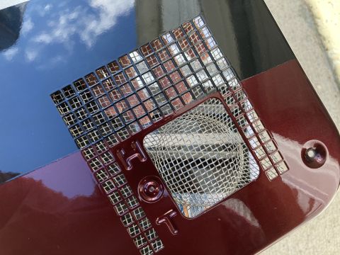2015 Ford F-550 - Close-up of a custom bug screen with "HOT" lettering, set against a metallic red background.