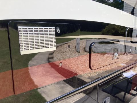 2015 Ford F-550 - Close-up of the exterior of a recreational vehicle, showing a large vent and a chrome-trimmed compartment.
