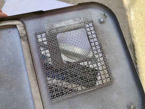 2015 Ford F-550 - A close-up view of a metal furnace part, showing a mesh screen over an opening.